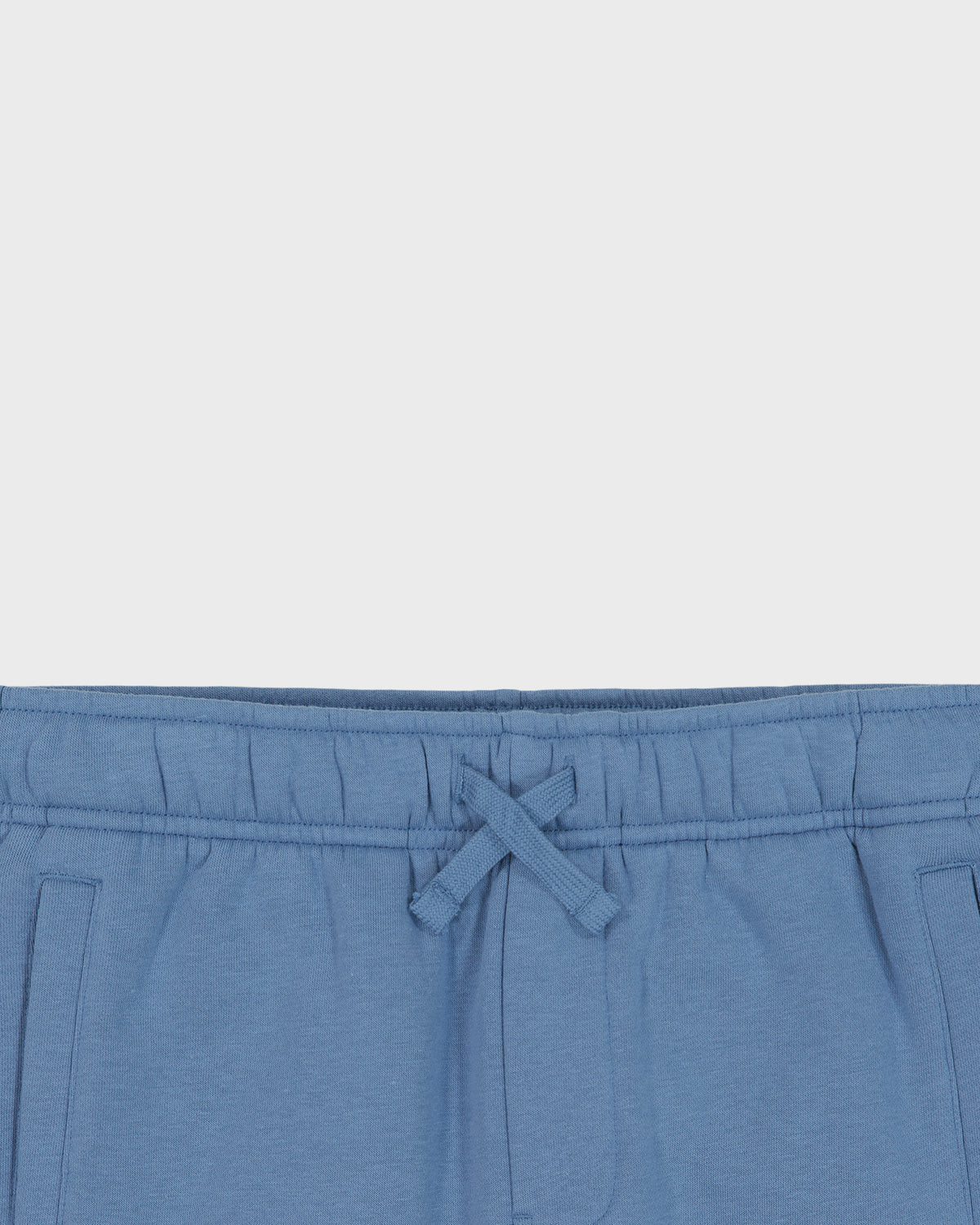 Blue pants with a drawstring on a light gray background