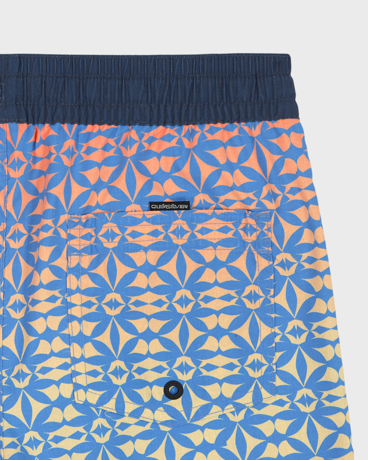 Blue and orange patterned shorts with a brand label on a white background