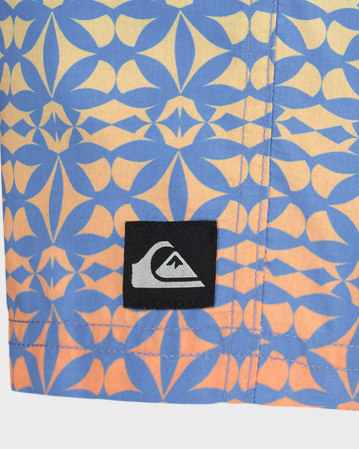 Close-up of a blue and orange patterned fabric with a brand label.